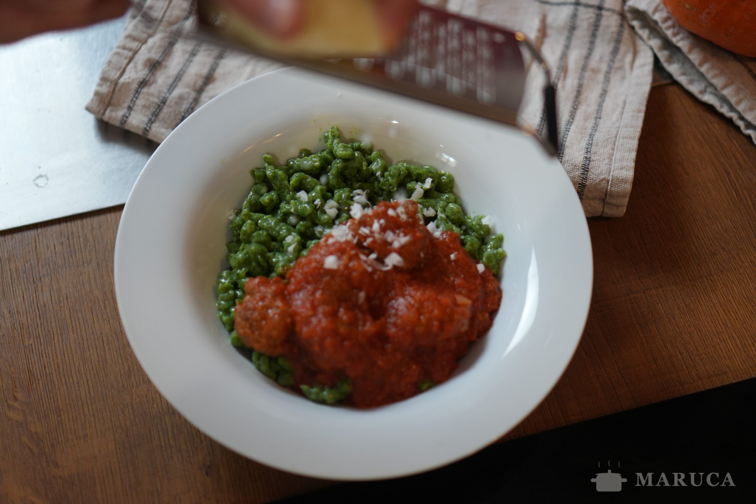 Rallando ricotta salata casera sobre el plato de spätzle