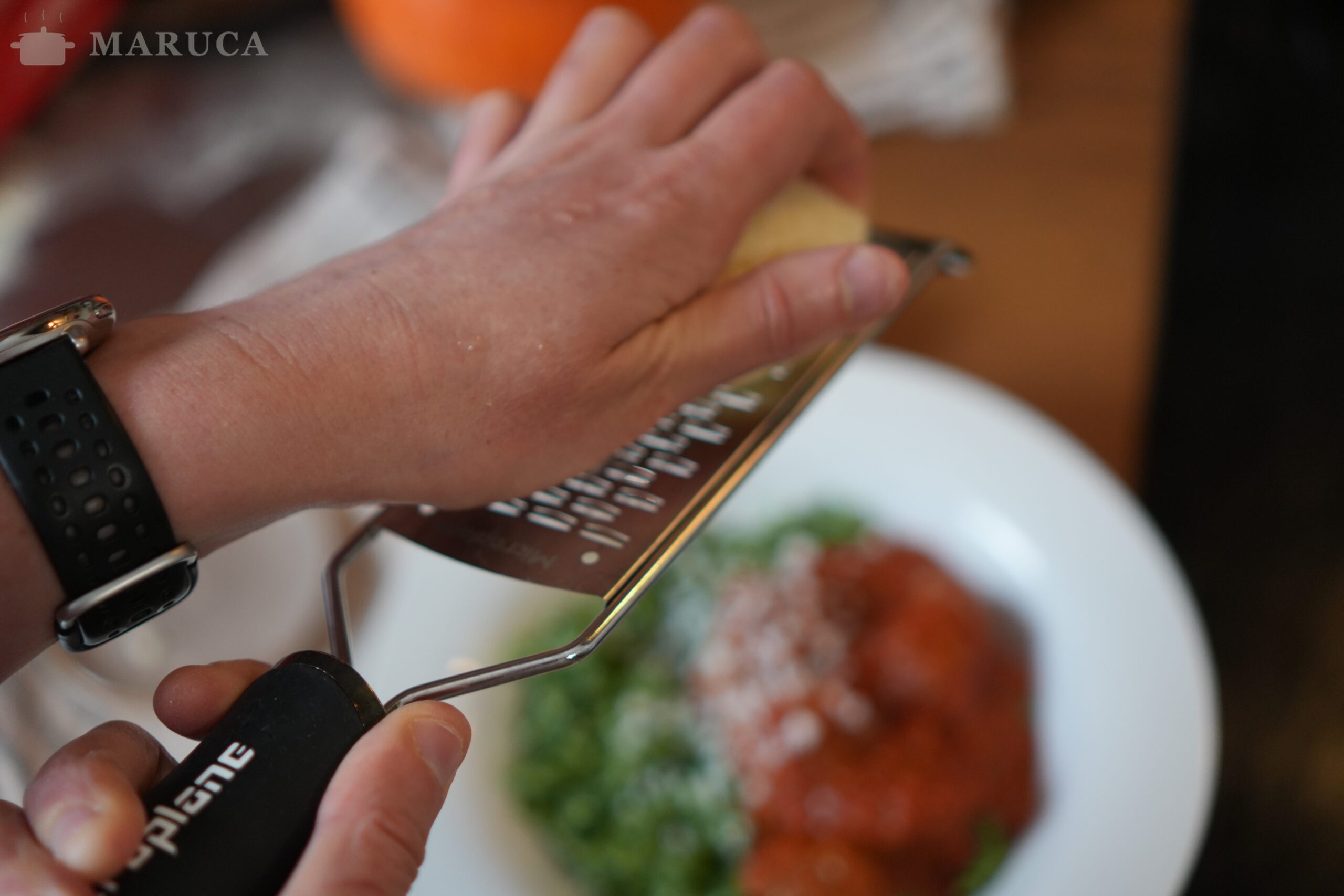 Rallando ricotta salata casera sobre el plato de spätzle