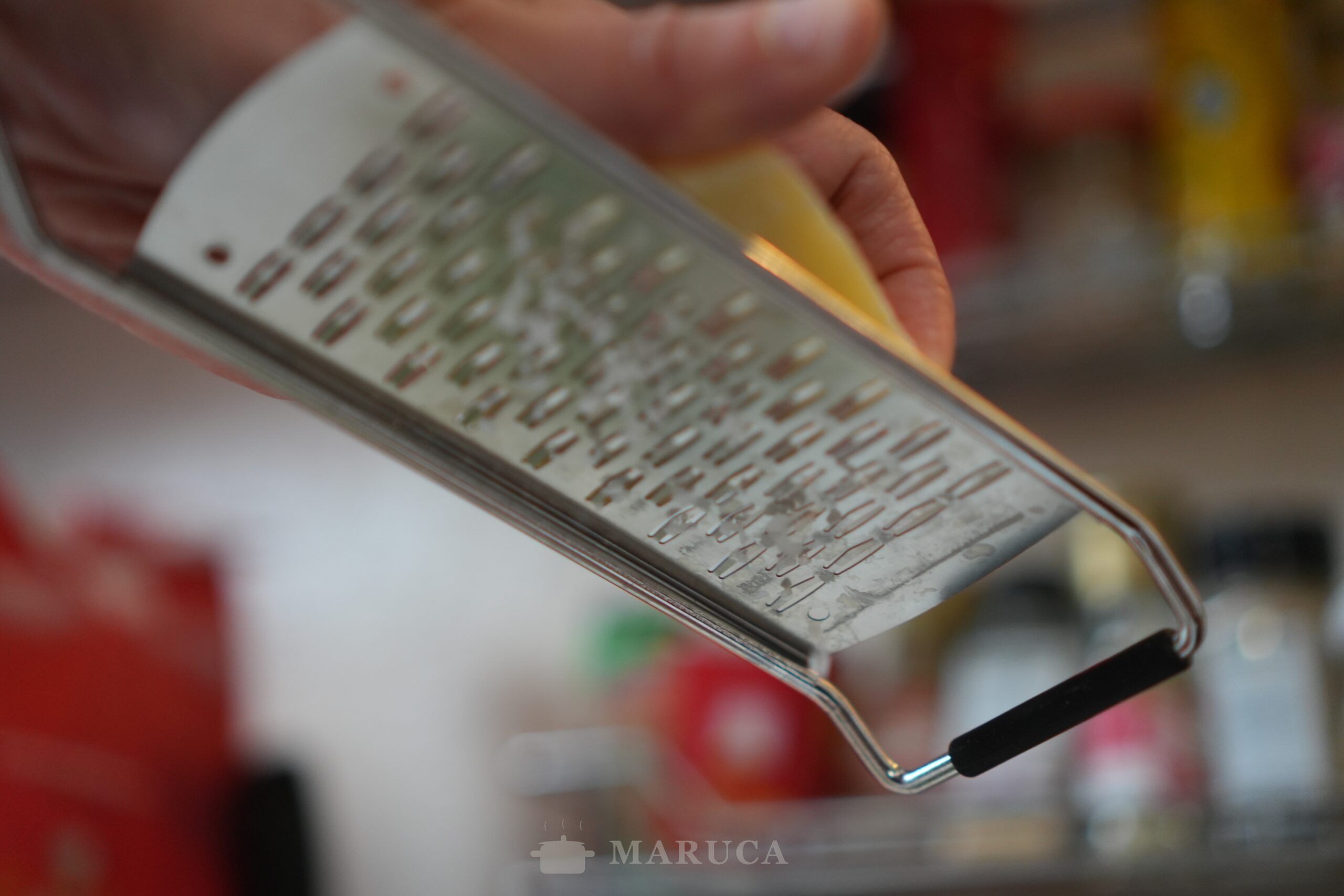 Rallando ricotta salata casera sobre el plato de spätzle