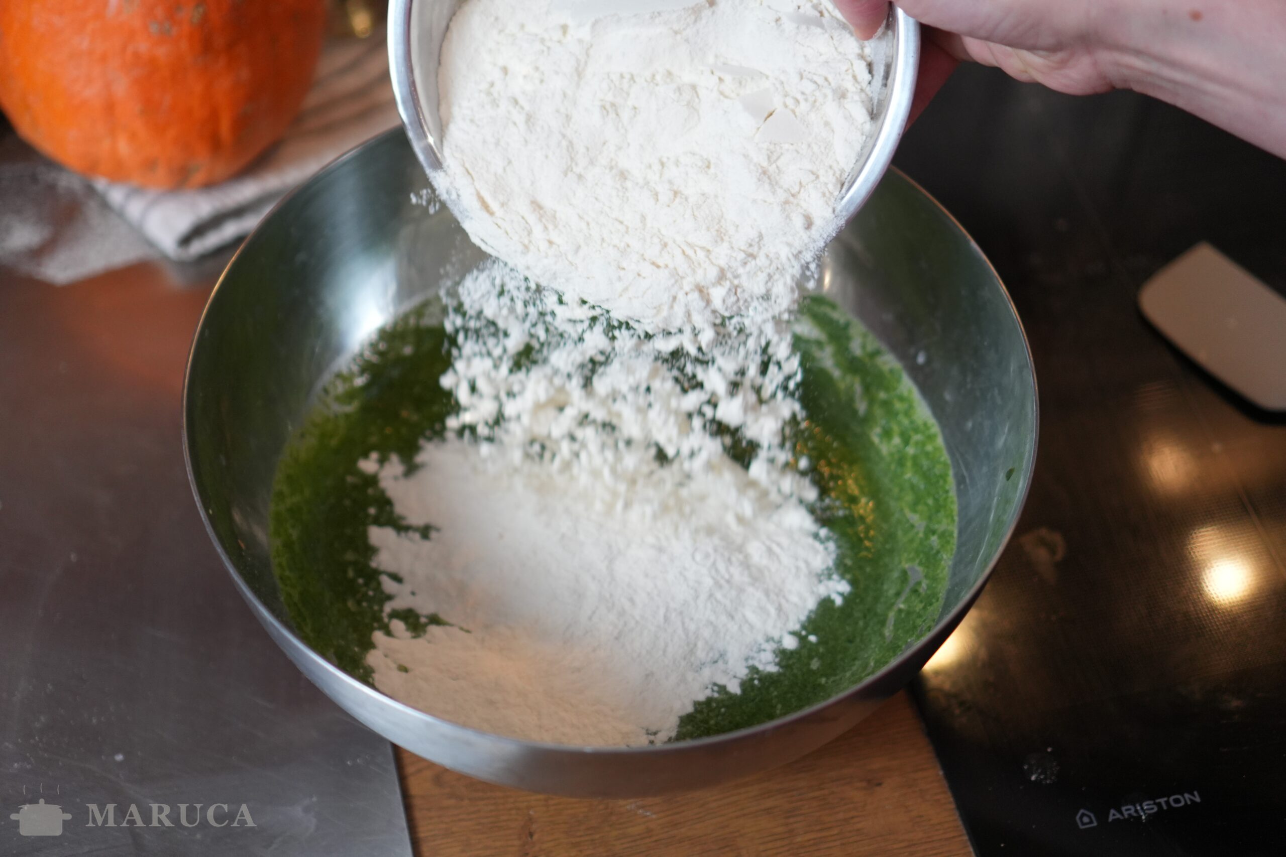 Agregando harina a la mezcla de espinaca para spätzle
