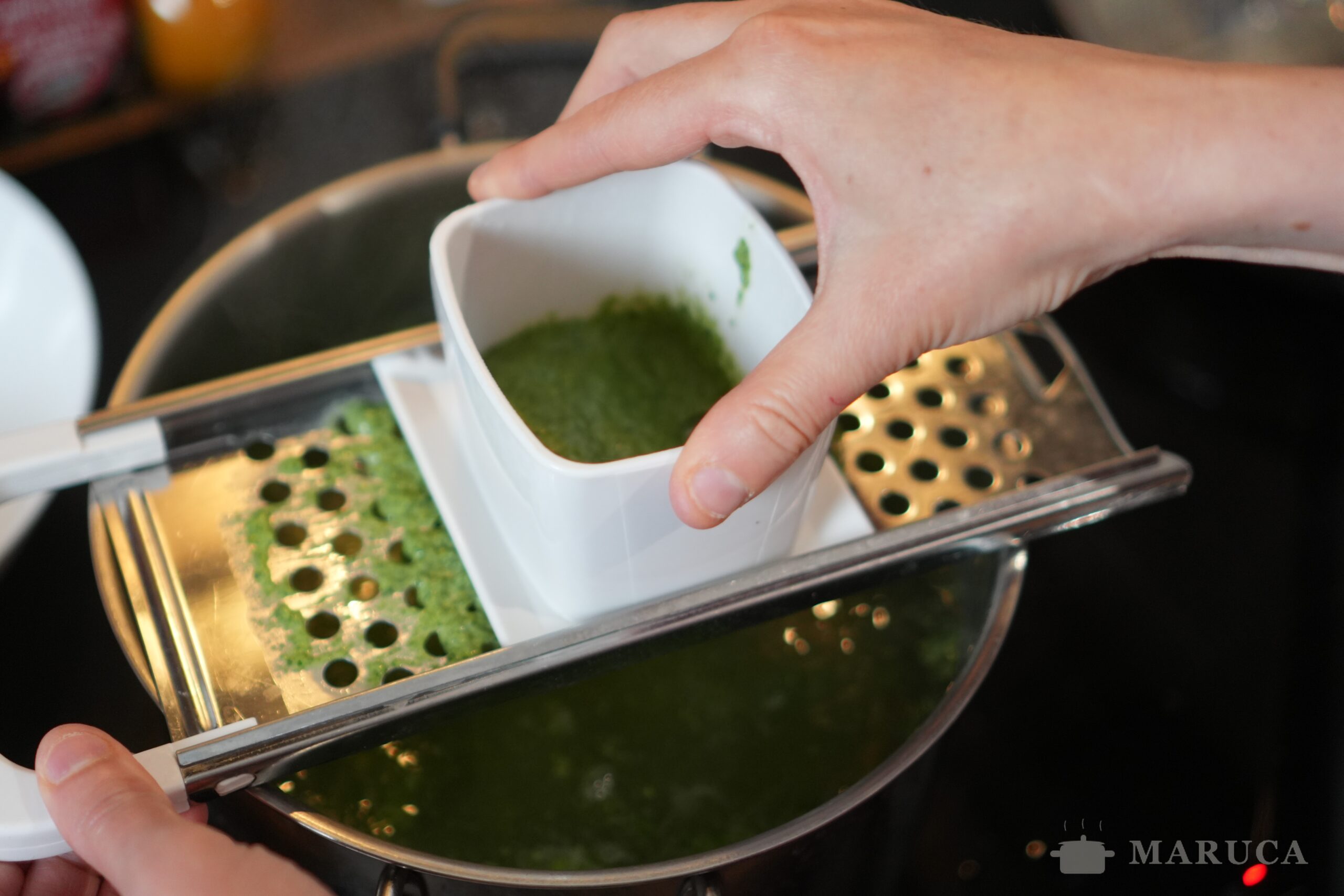 Haciendo spätzle con la máquina sobre agua hirviendo
