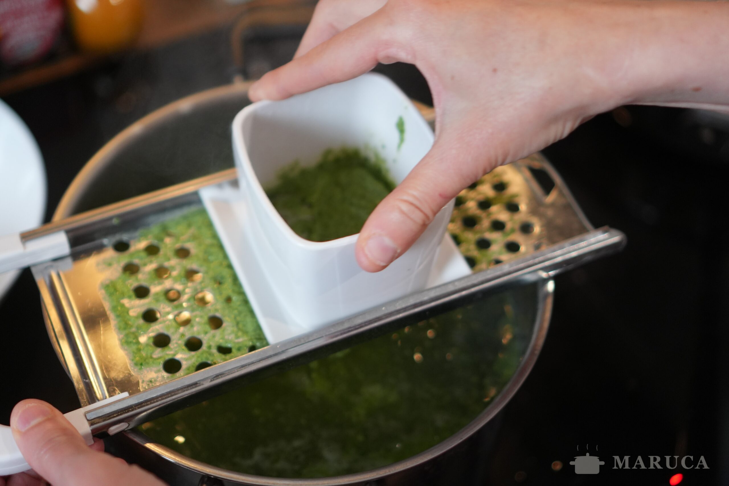 Haciendo spätzle con la máquina sobre agua hirviendo