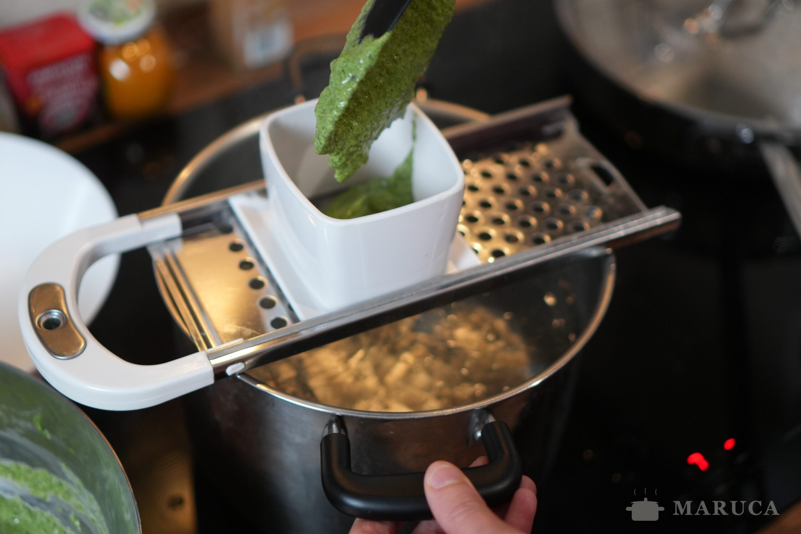 Haciendo spätzle con la máquina sobre agua hirviendo
