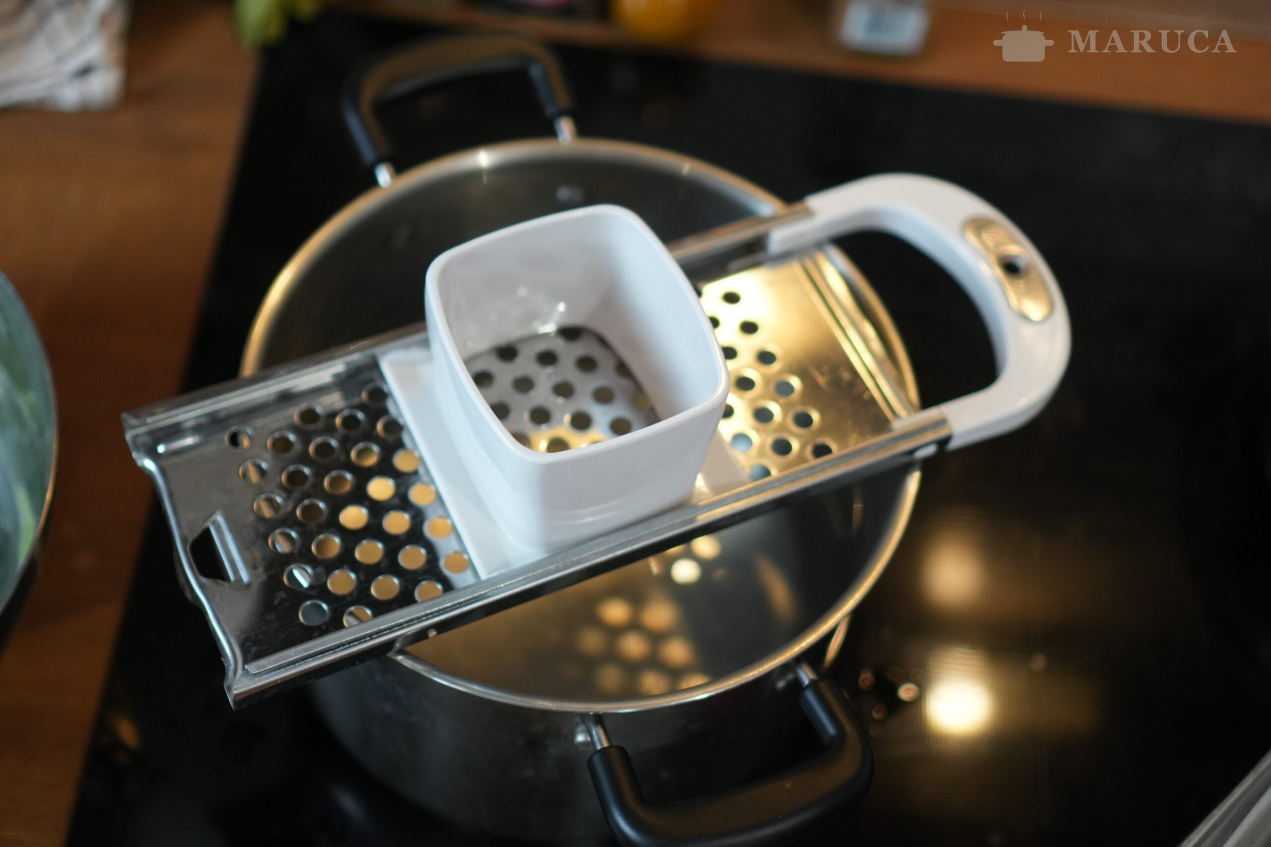 Máquina de hacer spätzle sobre la olla con agua hirviendo