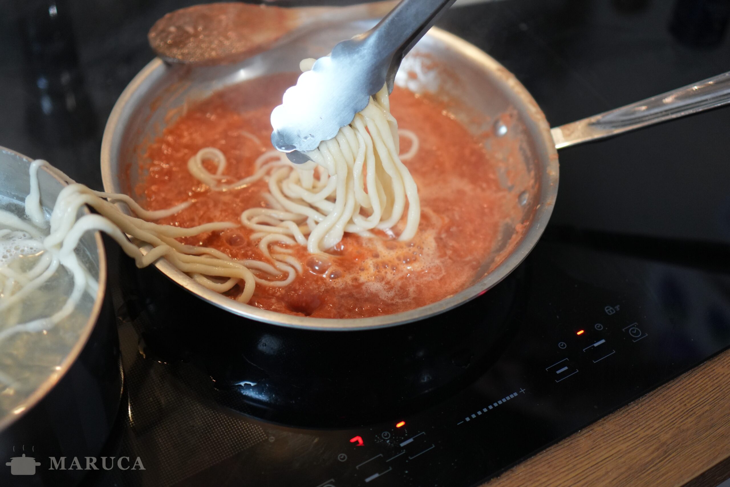 Pici all'aglione terminándose en la salsa