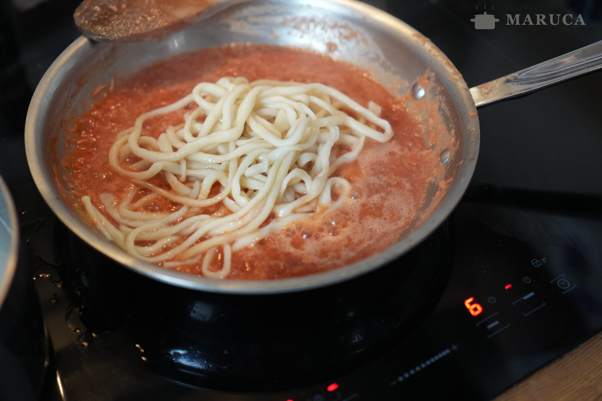 Pici all'aglione terminándose en la salsa