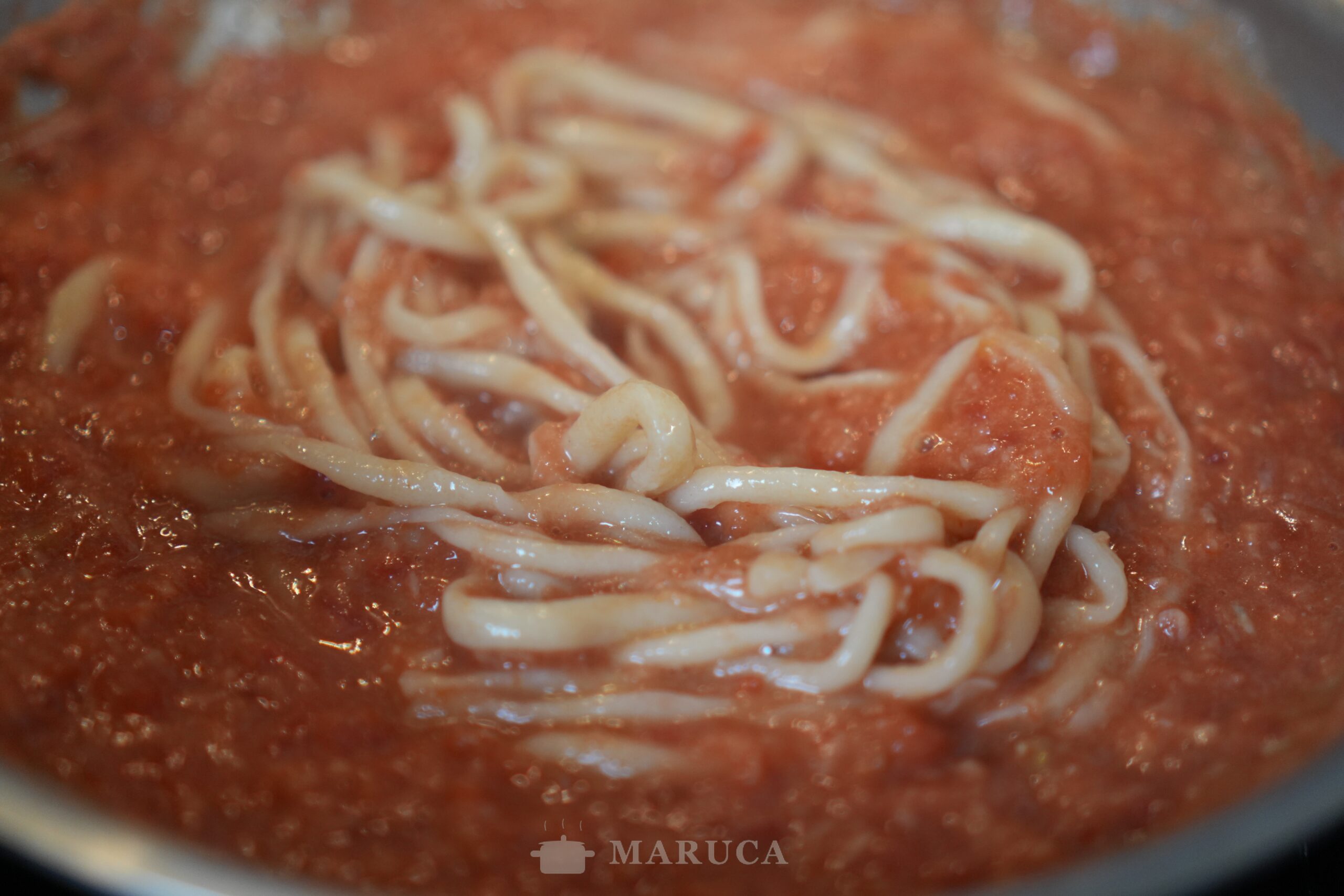 Pici all'aglione terminándose en la salsa