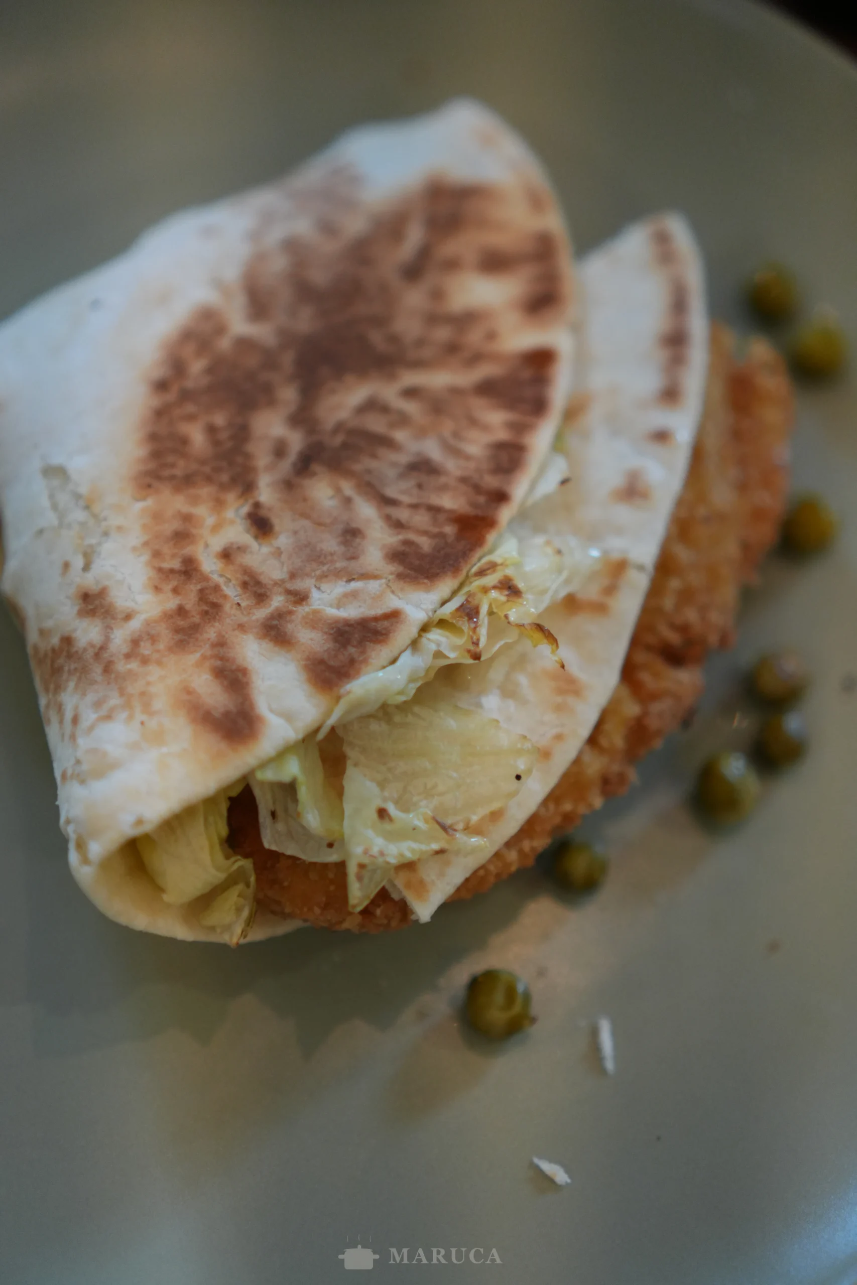 wrap de pescado, mayonesa, lechuga y arvejas cortado al medio