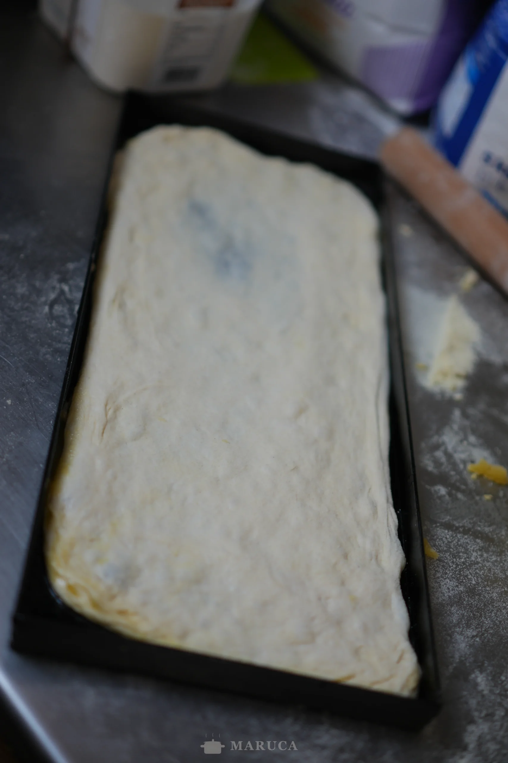 Masa de pizza estirada en teglia de ferro blu