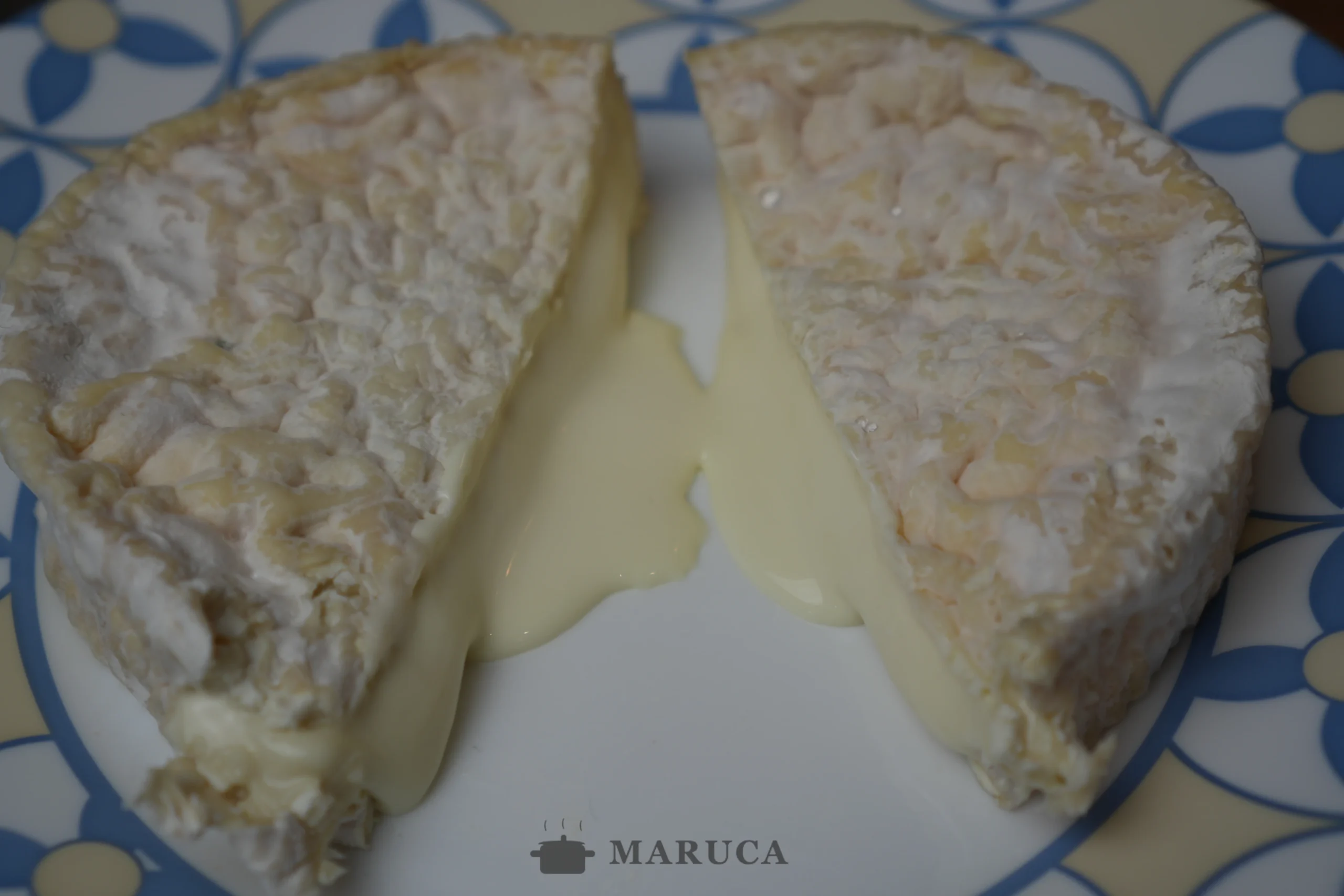 el camembert en hojaldre cortado al medio, queso derretido y cremoso