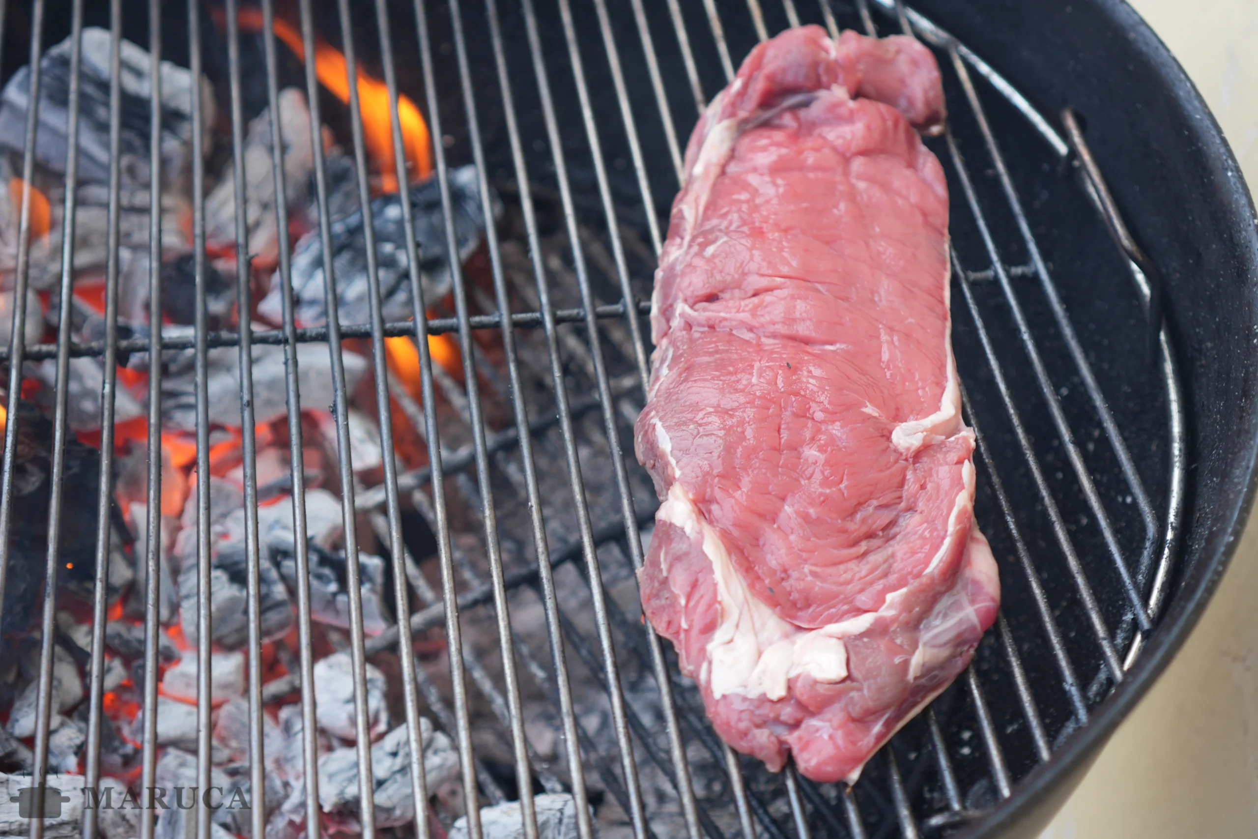 Un asado: bife, pollo marinado, costillas de cerdo y pan de pizza