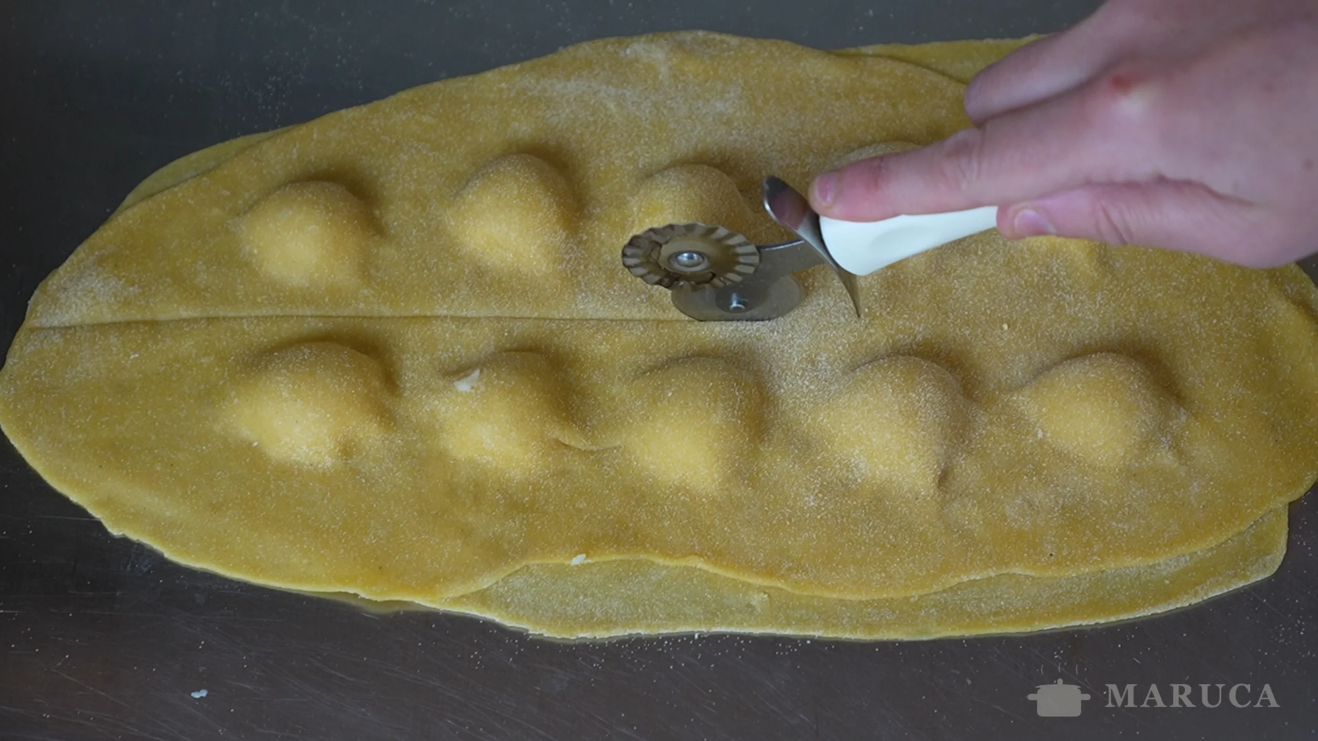 sellando los bordes de los tortelli con el tenedor