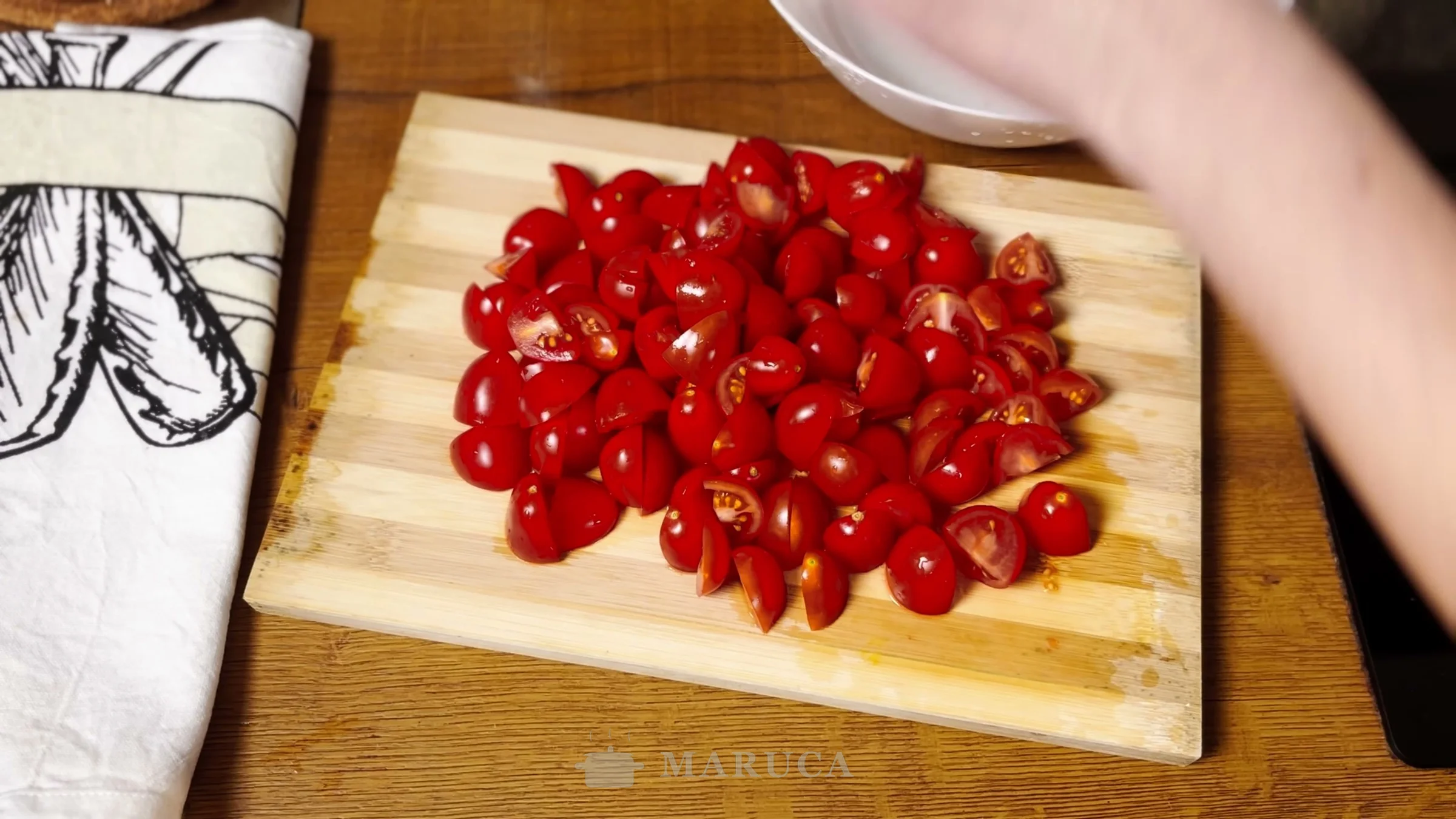 Tomates cherry cortados a la mitad sobre una tabla