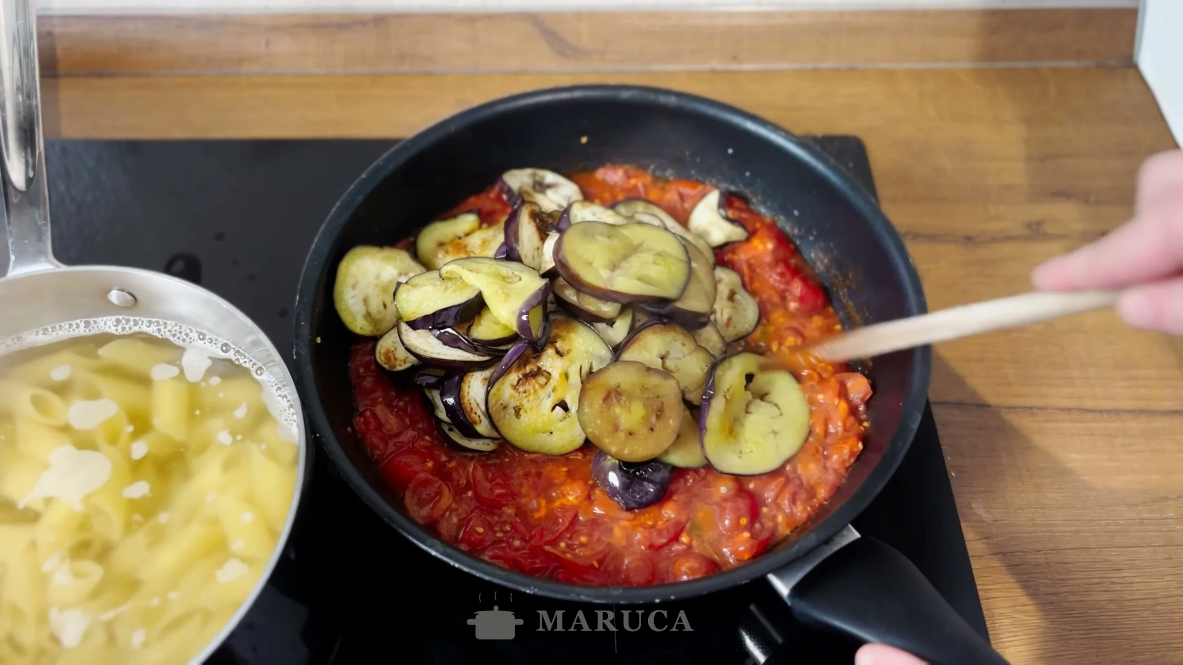Berenjenas agregadas a la salsa de tomate en la sartén
