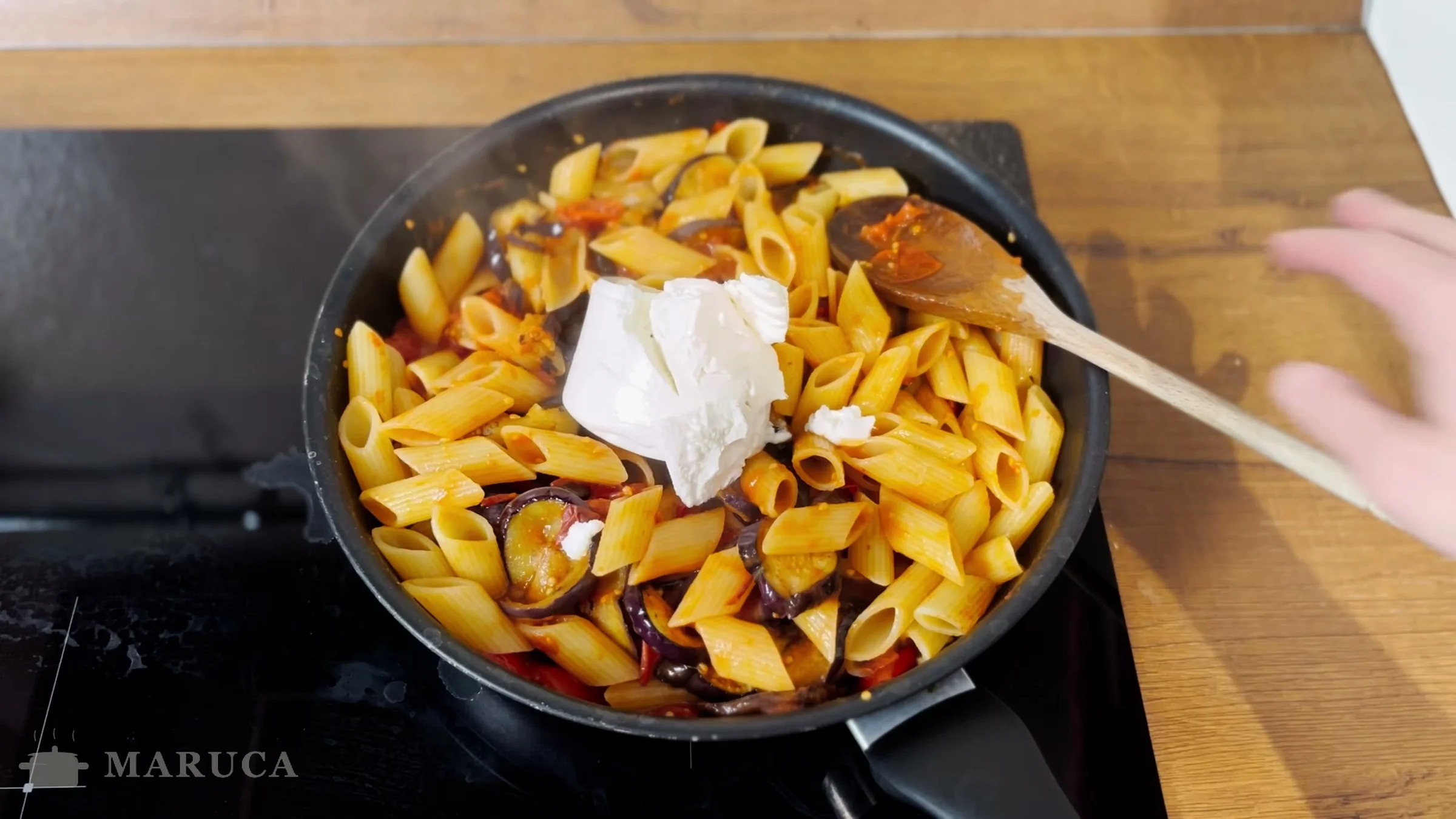 Ricotta fresca sobre la pasta con berenjenas y tomate