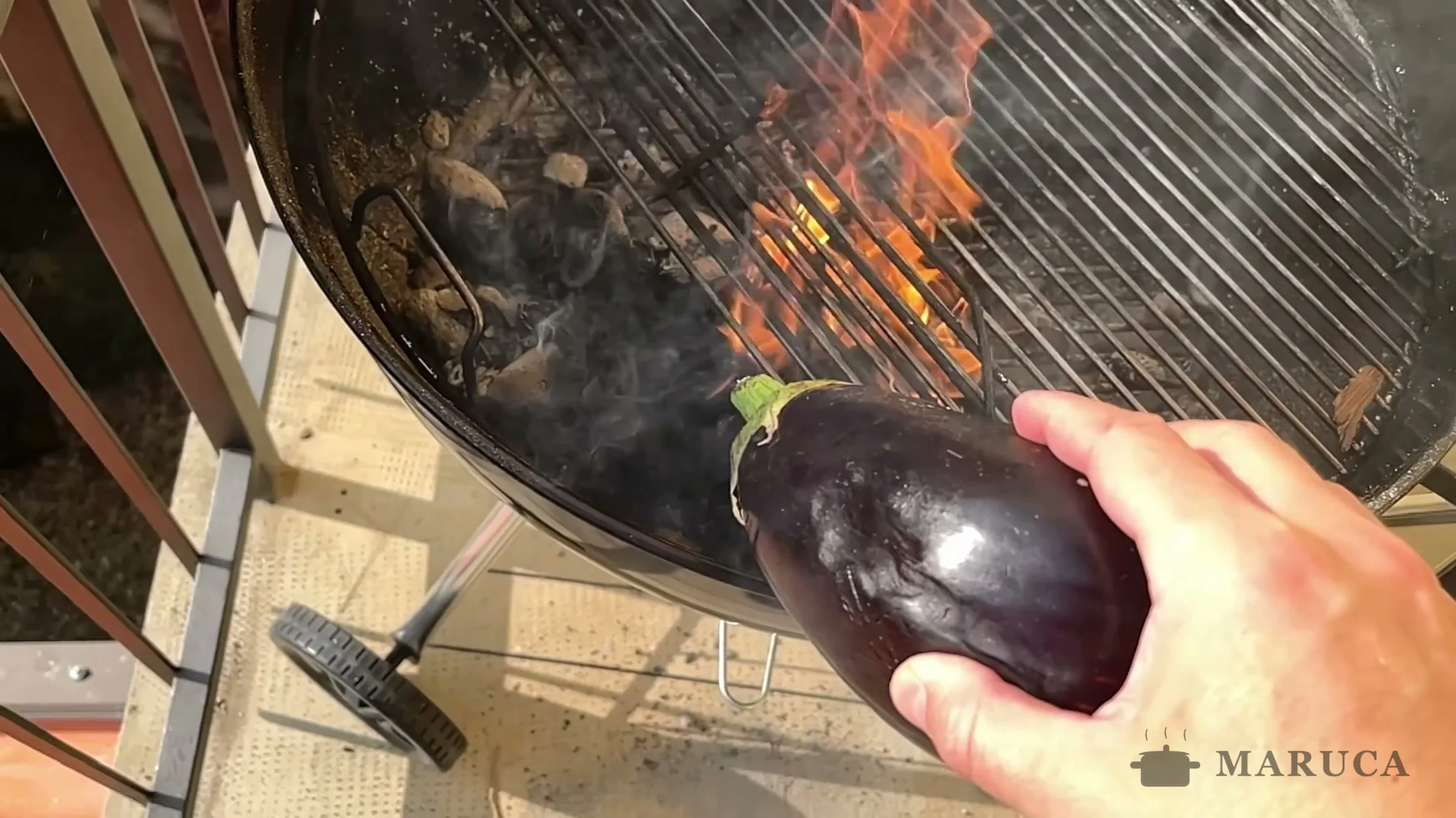 Poniendo una berenjena entera directo sobre las brasas de la parrilla