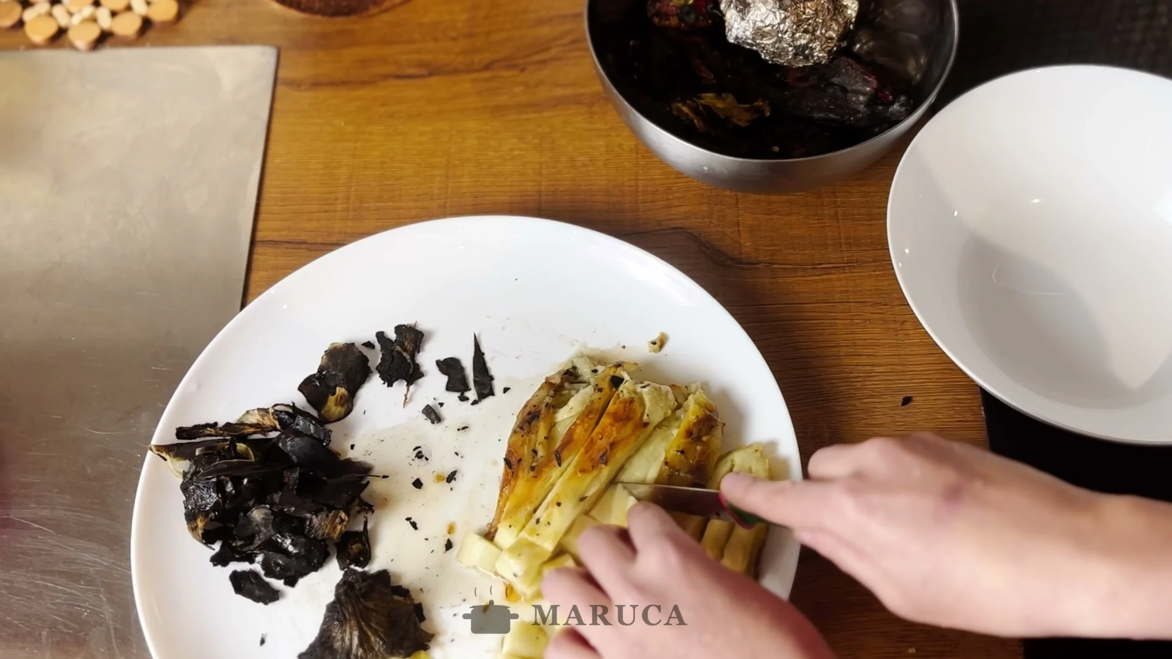 Pelando las berenjenas asadas a la parrilla sobre un plato