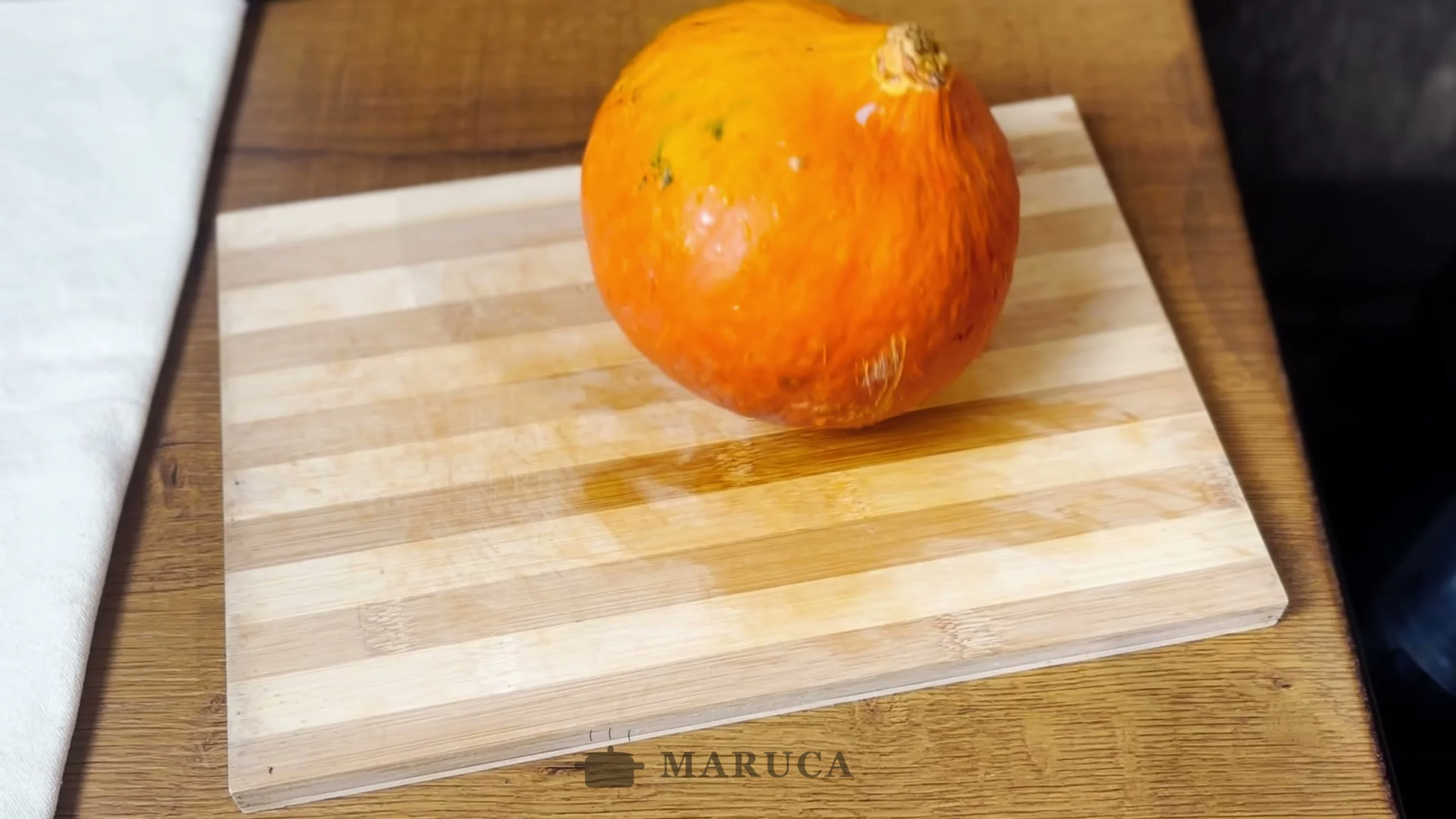 Zapallo Hokkaido naranja entero sobre la tabla de cortar