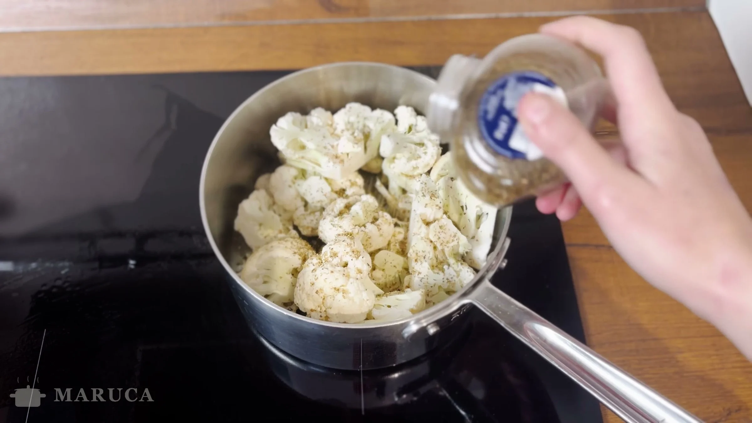 Coliflor con orégano en la cacerola mientras se agrega el agua