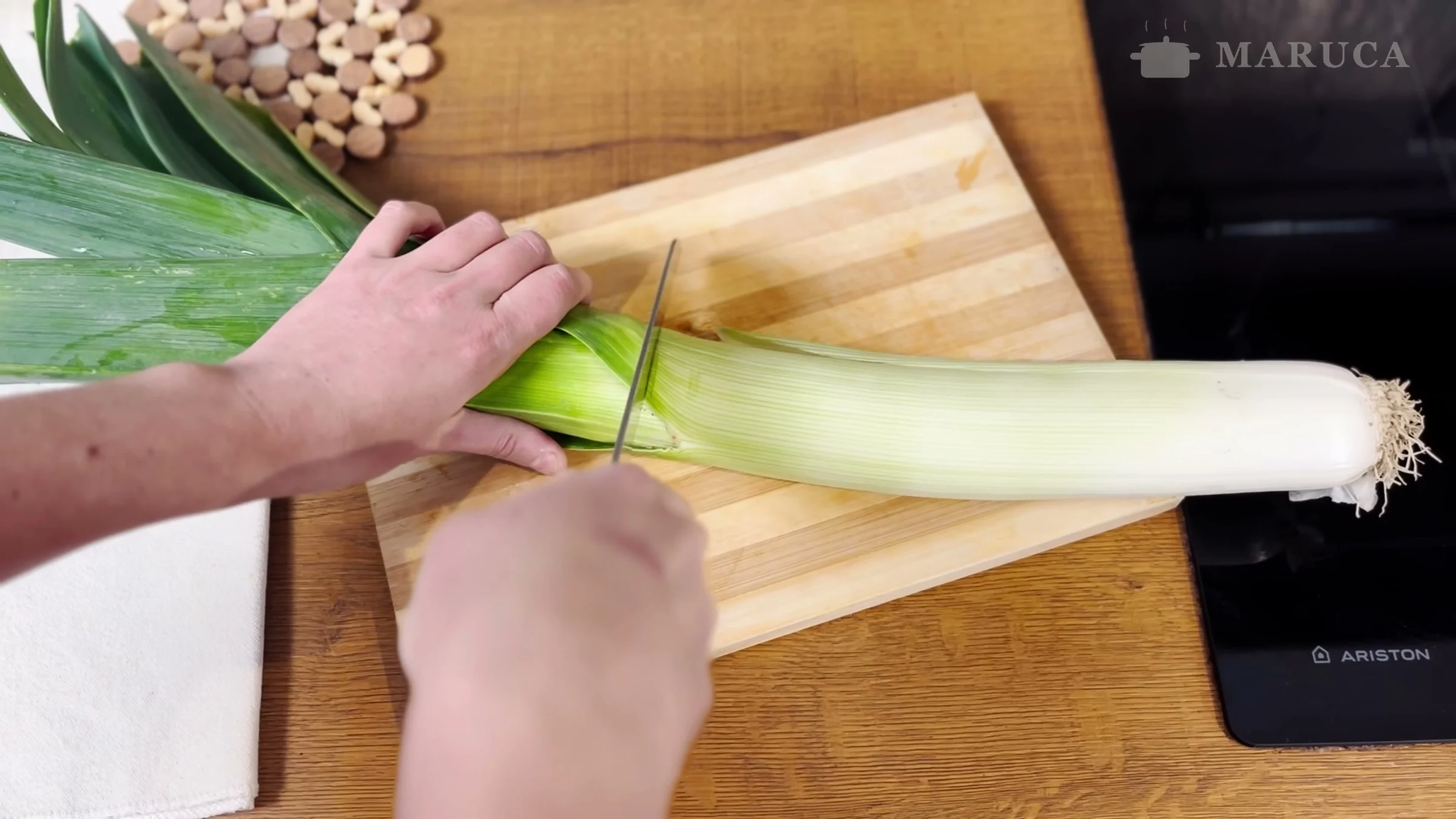 Cortando la parte verde de un puerro grande sobre la tabla