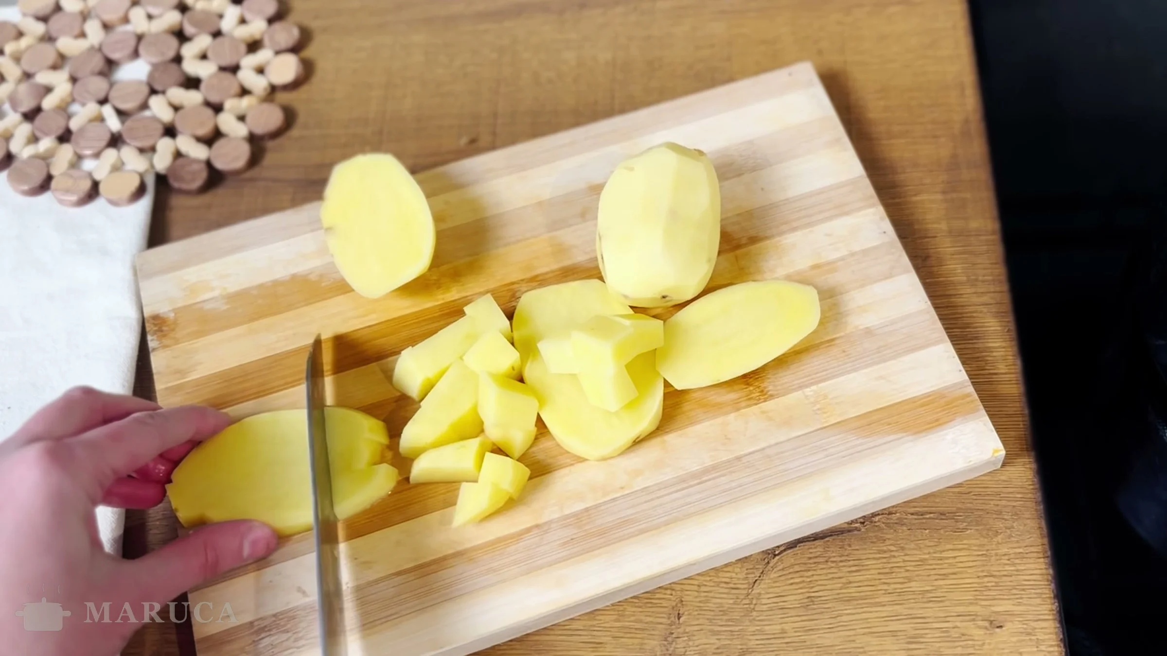 Papas peladas cortadas en cubos sobre la tabla