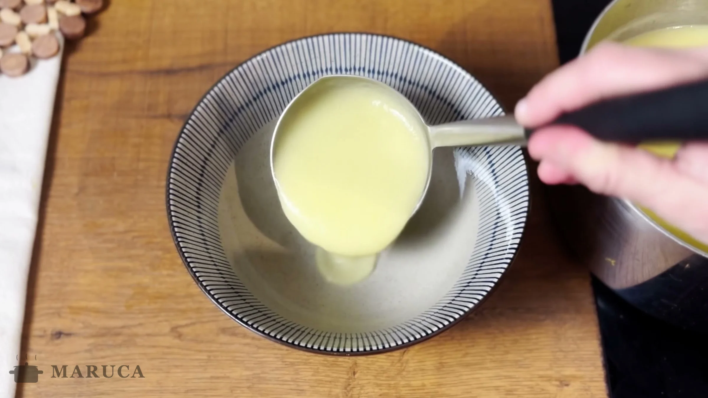 Sirviendo la sopa crema de puerro y papa con un cucharón en un bowl