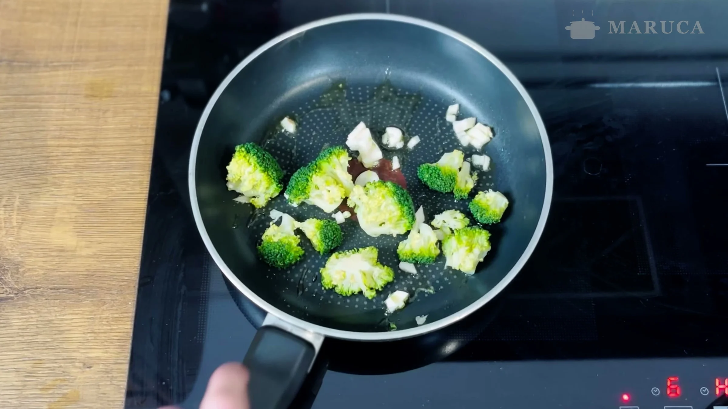 Flores de brócoli salteándose con ajo picado en una sartén