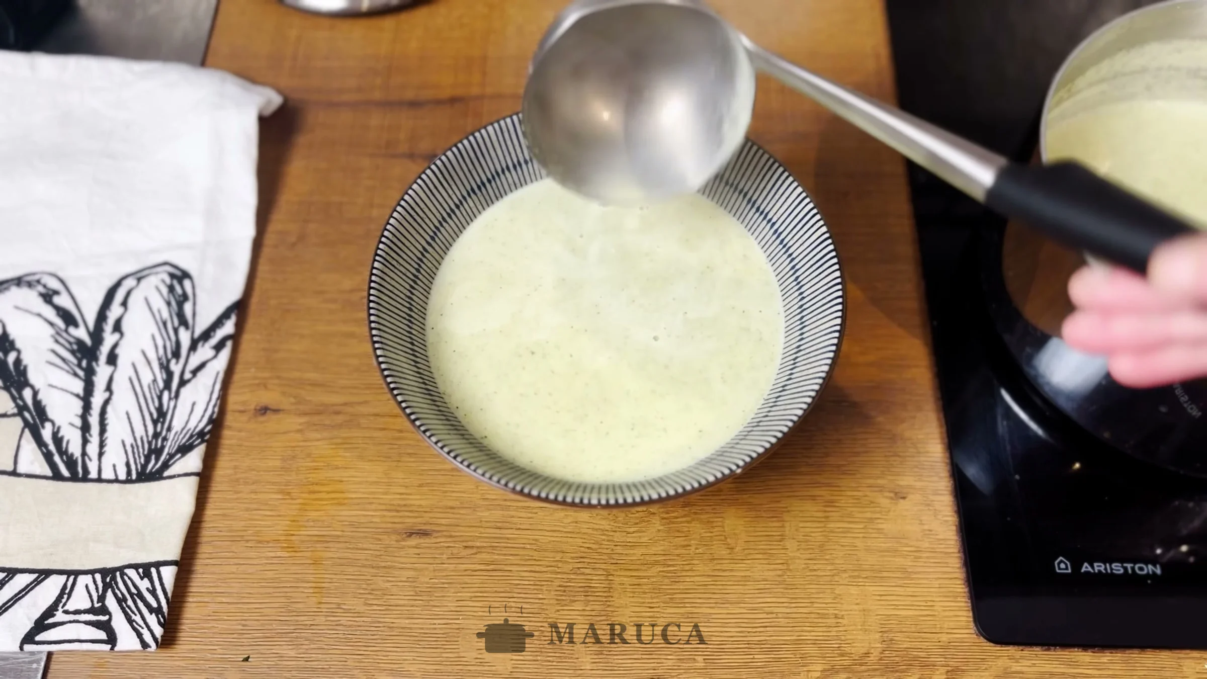 Sirviendo la sopa crema de brócoli con un cucharón