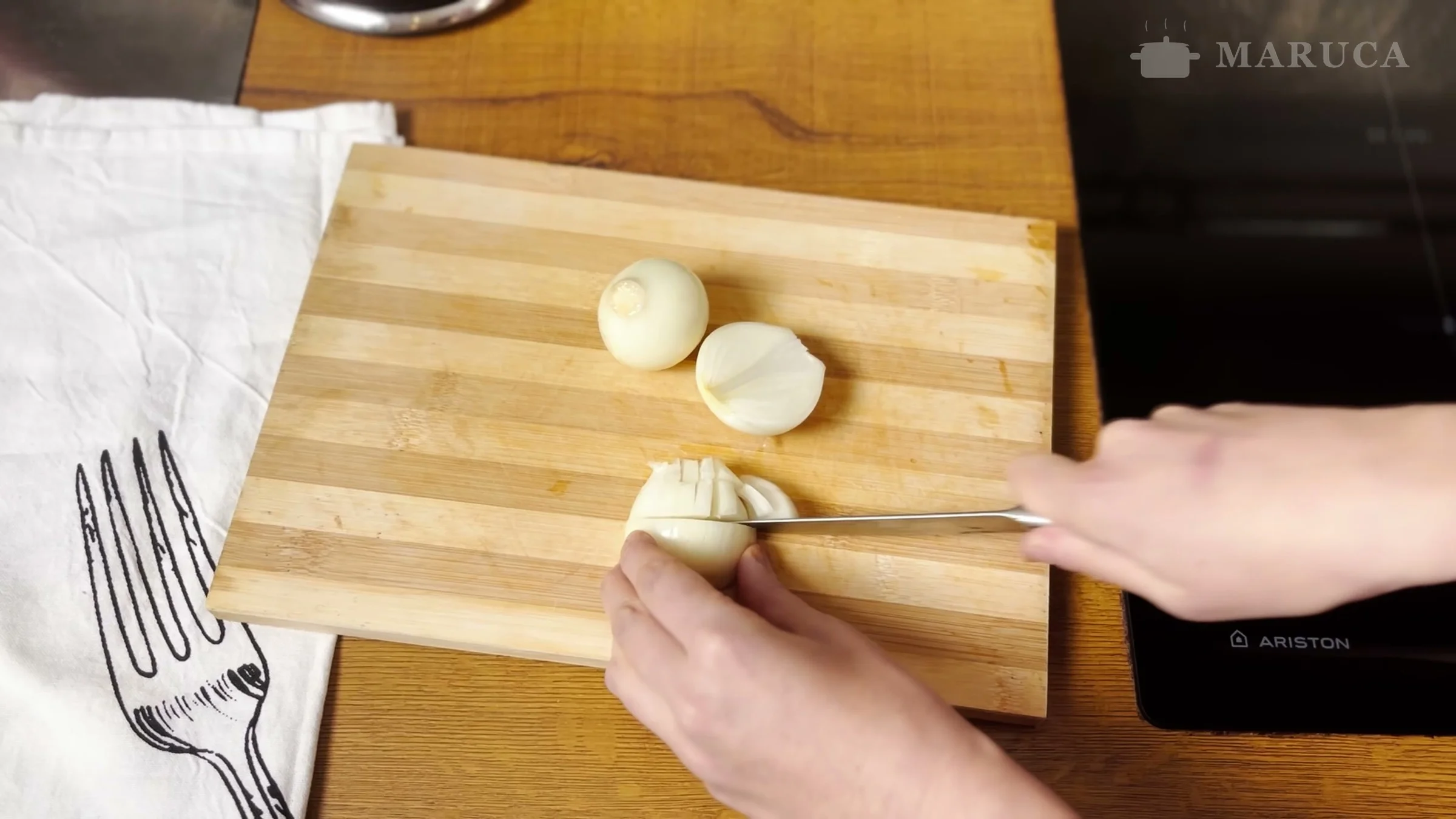 Cortando cebolla sobre la tabla para la sopa de papa alemana