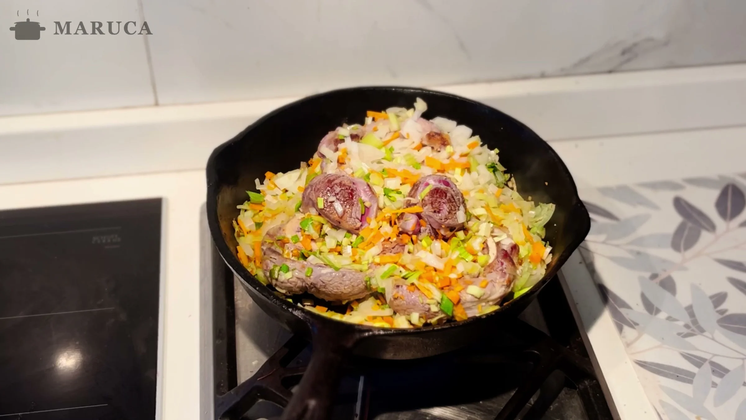 Osobuco con cebolla, zanahoria, apio y puerro en la sartén de hierro