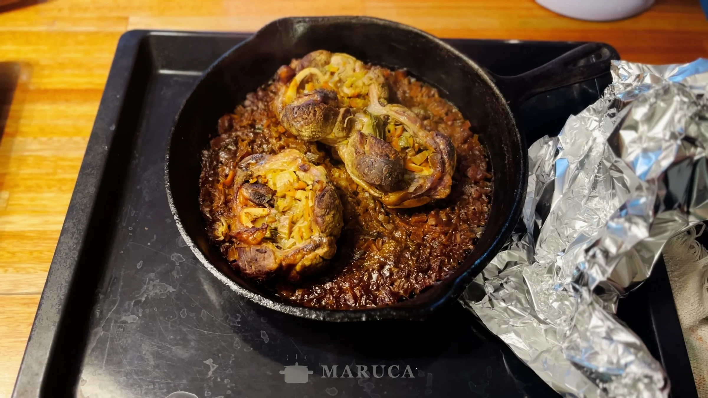 Osobuco recién salido del horno en la sartén de hierro, dorado y con su jugo