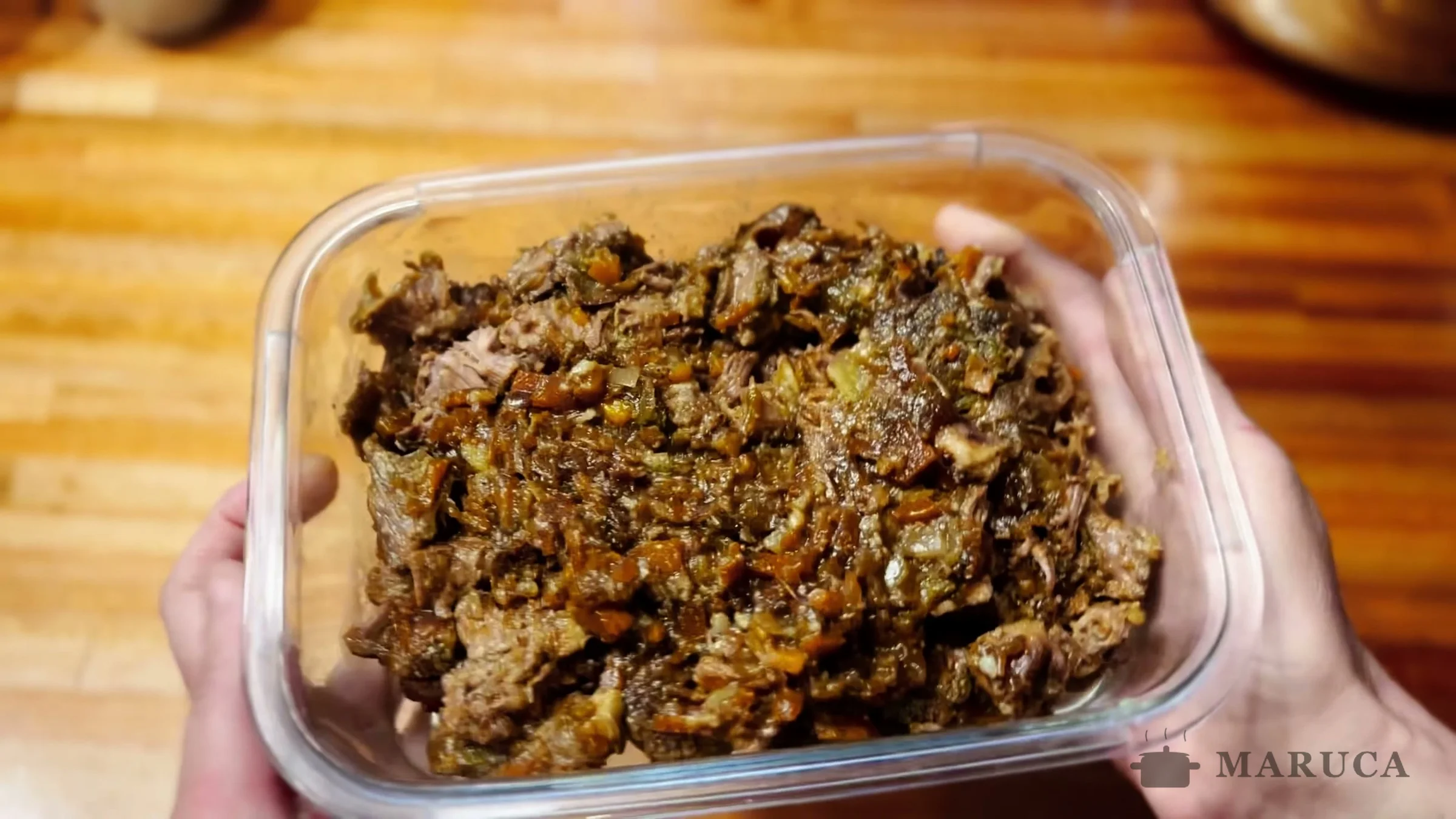 Relleno de osobuco desmenuzado con verduras guardado en un táper de vidrio