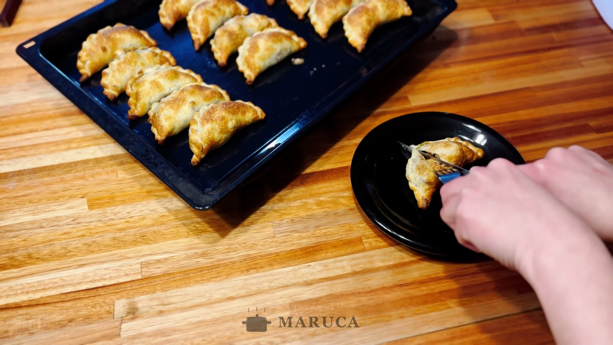 Cortando una empanada de osobuco al medio en un plato para ver el relleno